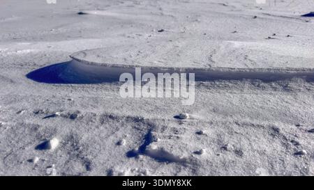 Detailed close-up of unique snow formations in the Gastein valley during winter. The sun highlights the textures and shadows on the snow-covered lands Stock Photo