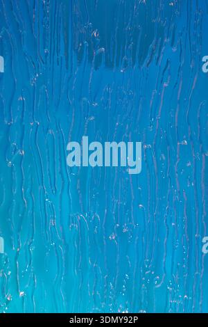 A mesmerizing close-up of holographic blue glass with embossed texture, creating an abstract and dynamic display of light and depth, perfect for moder Stock Photo