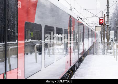 Modern high-speed electric train arriving at railway station platform at high speed on winter day Stock Photo