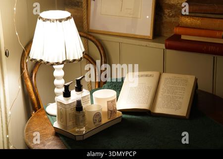 wicker-lamp-with-books-on-bedside-table-near-bed-against-white-brick