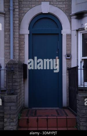 Elegant arched teal front door with fanlight on historic brick house in Cambridge.Cambridge,England Stock Photo