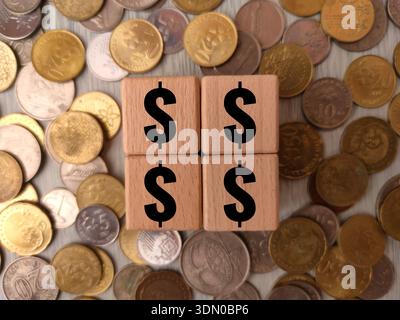 The image features four wooden blocks with dollar signs on a pile of coins. Stock Photo