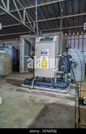 Industrial electrical control panel with booster pump and piping inside water treatment facility and utility plant. Stock Photo