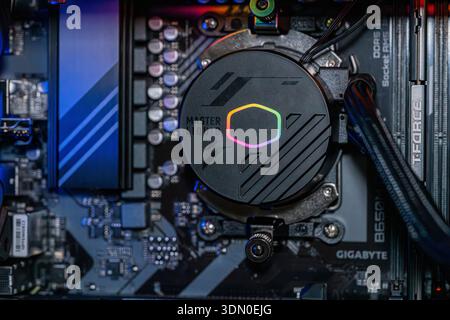 Gaming PC motherboard with RGB liquid cooling pump installed on processor inside modern high performance desktop computer technology Stock Photo