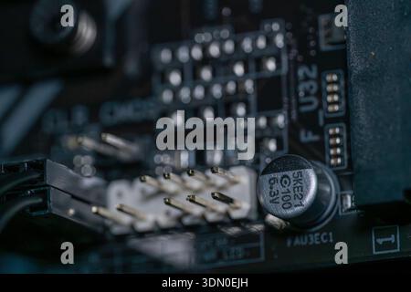 Macro close up of motherboard pin connectors and capacitor on modern electronic circuit board desktop computer hardware technology Stock Photo