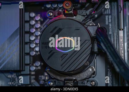 Gaming PC motherboard with RGB liquid cooling pump installed on processor inside modern high performance desktop computer technology Stock Photo