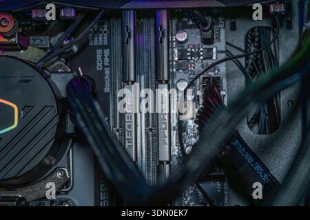 Gaming motherboard with DDR5 RAM memory modules and RGB liquid cooling system installed inside modern desktop computer hardware Stock Photo