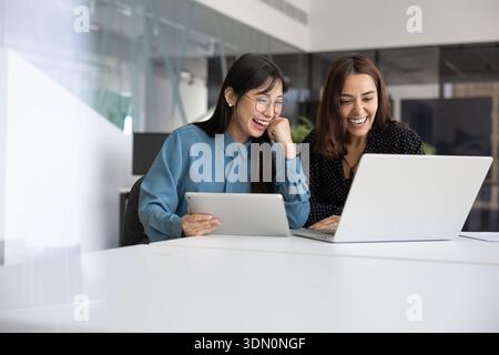 Two cheerful young multiethnic professional having fun and working together Stock Photo
