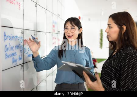 Diverse young female colleagues discussing project tasks schedule Stock Photo