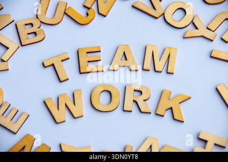 Team work text created from wooden letters on white background representing collaboration unity and group effort concept. Stock Photo