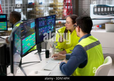 Team Of Diverse Technicians Using Industrial SCADA Software In Factory Stock Photo