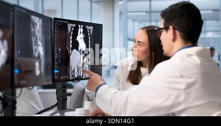 Surgeon And Technician Examine X-ray Of Patient's Fractured Bone. Stock Photo