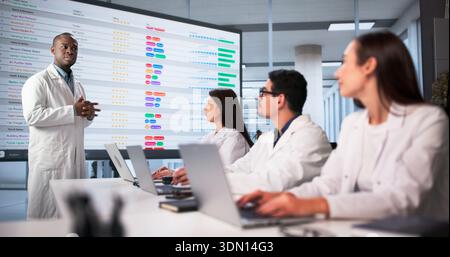 Meeting Of Diverse Medical Team In Hospital Office Discussing Code. Stock Photo