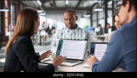 Focused Team Meeting Analyzing Business Plan With Diverse Group Stock Photo