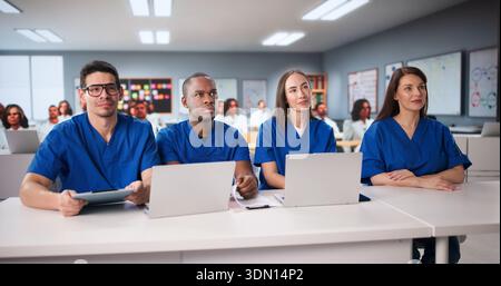 Medical Students In Lecture Hall Using Laptops To Study Medicine. Stock Photo