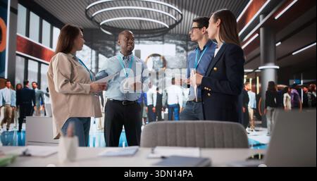 Successful Professionals Engaged In Productive Discussion At Business Conference Booth Stock Photo