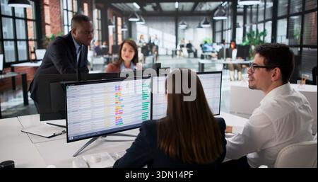 Diverse Business Team Analyzing Data On Computer Screen In Office. Stock Photo