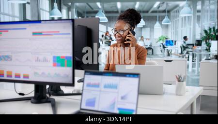 Smiling African Businesswomen Talking To Clients On Phone And Laptop. Stock Photo