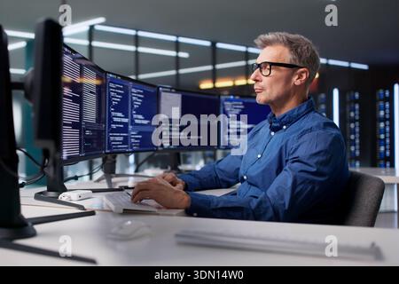 The Mature Programmer Is Developing Cyber Security Software For Businesses Stock Photo