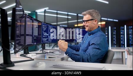 Excited Programmer Celebrates Win Optimizing Software Code In His Office. Stock Photo