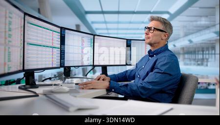 Skilled Office Manager Analyzing Data Across Multiple Business Monitors Stock Photo
