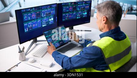 Skilled Engineer Monitoring Electricity Generation In Smart Energy Plant Control Room Stock Photo