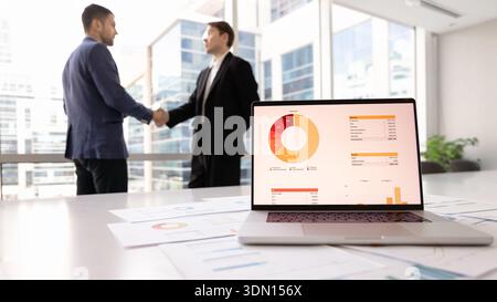 Close up laptop displaying financial analytics placed on table Stock Photo