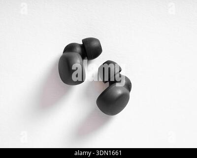 Black wireless earbuds providing portable, high quality audio experience on a clear white background Stock Photo