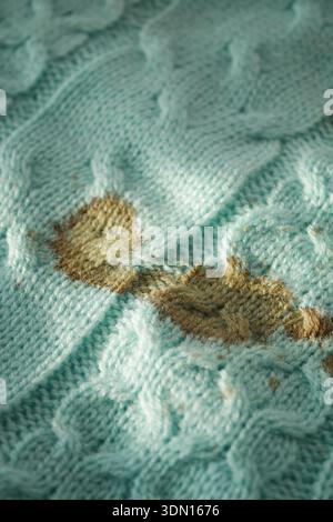 Knitted fabric with stains on a light blue background Stock Photo
