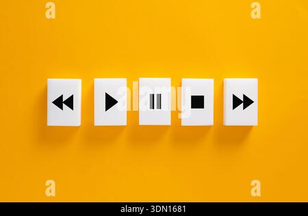 Control buttons for multimedia player showing play, pause, stop, rewind, and fast forward functions on yellow background Stock Photo
