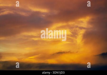 Dramatic sunset sky with vibrant orange and yellow clouds creating a fiery atmosphere Stock Photo