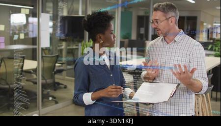Discussing developer in denim and manager in plaid shirt at office with clipboard, code on glass Stock Photo