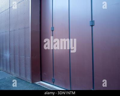 Modern building facade with perforated metal screen and dark brown panels Stock Photo