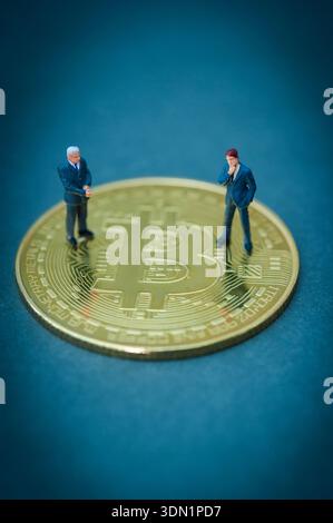 Miniature business figures standing on a bitcoin coin representing cryptocurrency markets, digital assets, and modern financial strategy Stock Photo