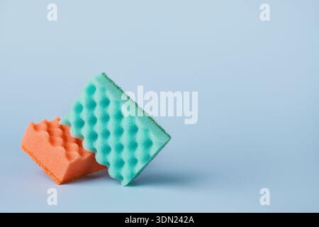 Two orange and Mint household sponges with scrubbing surfaces on light background Stock Photo
