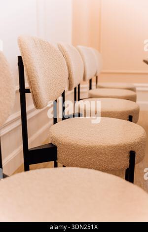Modern beige boucle chairs in minimalist interior with warm light, soft focus and copy space Stock Photo