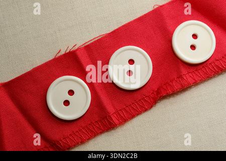 Creative exploration with red fabric and white buttons brings joy and style. Stock Photo