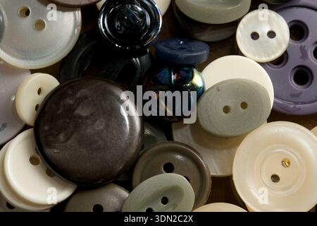 Colorful buttons of various shapes and textures are scattered about. Stock Photo