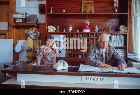 Greece, Aegina Island, traditionally decorated hotel reception, with two older staff members working. Stock Photo