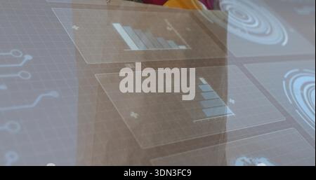 Displaying translucent panels over glass panel in office, showing blue charts and radar Stock Photo
