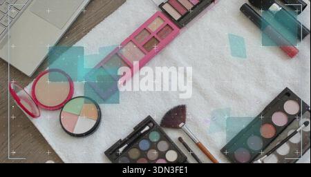 Placing makeup products on white towel over wood table, featuring long pink palette, fan brush Stock Photo