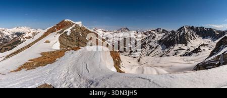 A significant amount of spring snow remains below Dorthy Peak at the head of Rustler Gulch in the Elk Range Mountains near Crested Butte, Colorado. Stock Photo