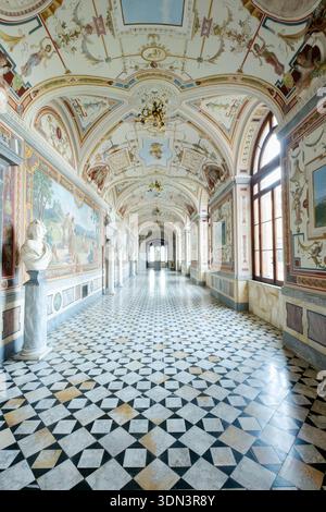 Grand castle gallery featuring intricate frescoes, classical busts, and a checkered marble floor, Torre Alfina, Italy Stock Photo