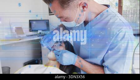 Leaning male dentist in scrubs mask gloves examining patient in chair with mirror, probe, overlay Stock Photo