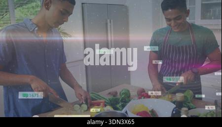 Slicing fresh veg, two men preparing meal in home kitchen, with knives, striped apron, overlays Stock Photo