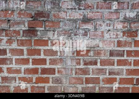 Aged red brick wall with worn surface and visible mortar in Borghetto sul Mincio Italy, suitable as background or texture for design, architecture and Stock Photo