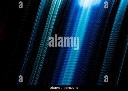 Vertical blue digital light lines forming abstract depth and futuristic data flow on dark technology background Stock Photo
