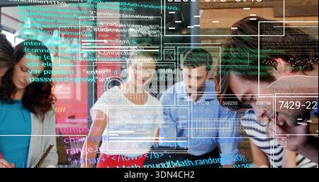Leaning six-member team in casual dress studying laptop and docs at office table with code overlays Stock Photo