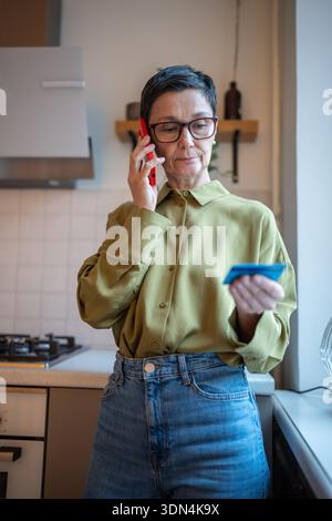 Scammers misleading elderly woman to share personal data and bank card number information on phone. Stock Photo