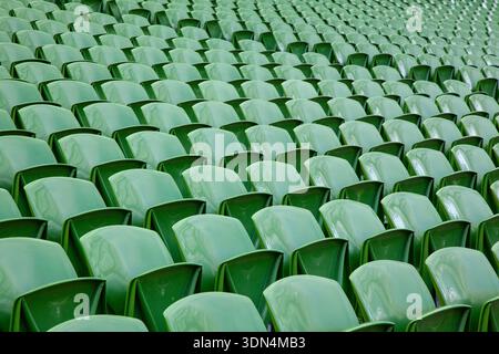 Rows of empty green plastic seats in a sports stadium Stock Photo